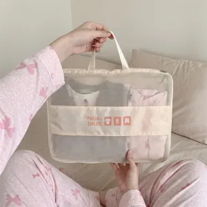 Close-up detail of a cream-colored mesh travel packing cube filled with folded clothes.