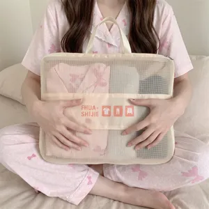 Close-up view of a mesh portable travel storage bag held in hands in a bedroom setting