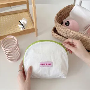 Close-up van lichtgewicht halfronde cosmetische tas met groene rits en paars label
