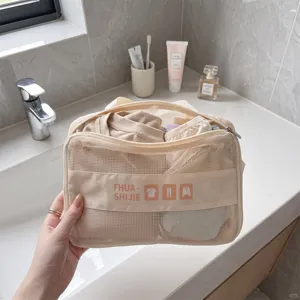 Close-up of a mesh travel storage bag held over a bathroom sink for organization