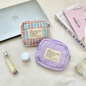 Detailed view of macaron colored quilted mini storage bags on a lifestyle desk setup