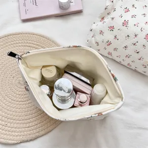 Vista interna della borsa cosmetica floreale con spazio per cura della pelle e trucco