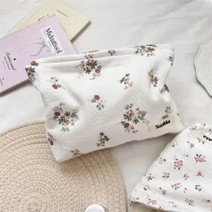 Vista dettagliata della borsa da trucco trapuntata bianca con motivi floreali vintage