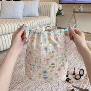 Handheld delicate floral embroidered drawstring storage bag showing cosmetic organization