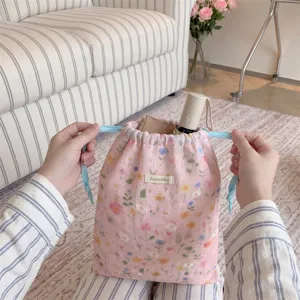 Detailed view of floral drawstring storage bag holding everyday essentials