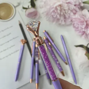 Close-up view of a purple diamond-topped glitter ballpoint pen with rose gold trim details.