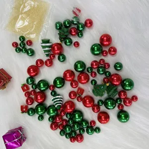 Close-up detail of assorted red and green pearls and miniature Christmas trees for vases.