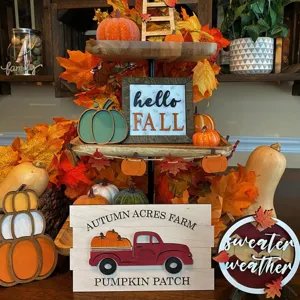 Dettaglio decorativo del vassoio autunnale con insegne in legno di zucca e foglie.