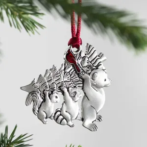 Metal Christmas tree ornament featuring cute forest animals carrying a tree with a red cardinal accent.
