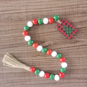 Weihnachts-Holzperlen-Girlande Detail mit rot weiss grünen Perlen, Karo-Baum-Etikett und Quaste.