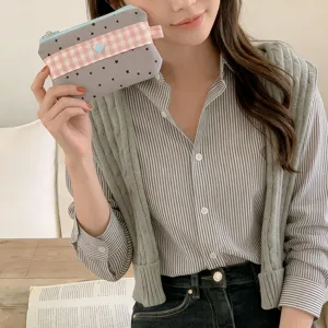 Handheld star and gingham pattern pencil pouch shown by a model for school storage.