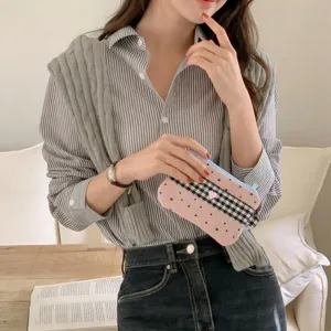 Cute pink plaid pencil pouch with star pattern held by a model in a stylish casual outfit
