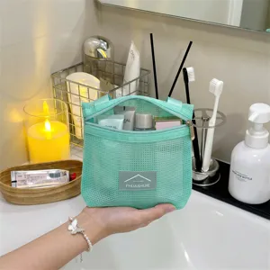 Mintgrüne Netztasche für Toilettenartikel in Badezimmerumgebung mit Kosmetika
