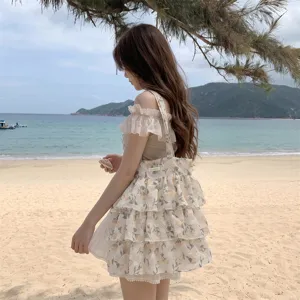 Detailaufnahme einer Tragetasche mit gelbem Tulpenmuster und Rüschen am Strand
