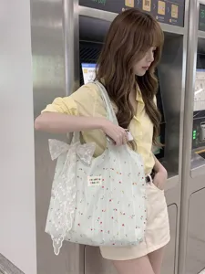 Elegante bolso tote grande con flores y rayas verde claro y un lazo de encaje