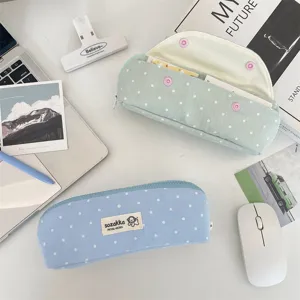 Dettaglio dell'astuccio in tessuto a pois color macaron con chiusura a scatto