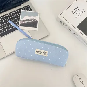 Primo piano di un astuccio azzurro a pois con una simpatica toppa con logo