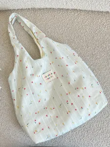 Bolso tote grande de rayas florales en verde claro con interior espacioso y correa