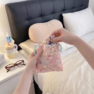 Close-up detail of a floral fabric drawstring pouch organizer bag held by hands