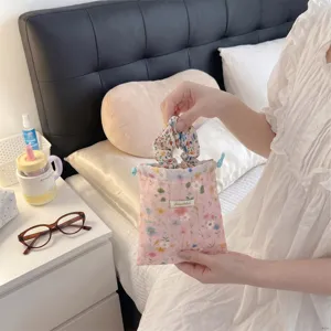Detailed view of a floral drawstring pouch and matching scrunchie in a cozy bedroom setting.
