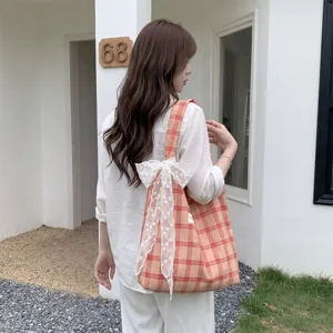 Borsa tote a scacchi arancione con grande fiocco decorativo in pizzo bianco sulla spalla