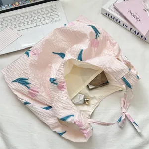 Vue détaillée d'un cabas rose plissé avec motif tulipe brodé et bandoulière à cordon