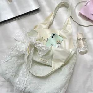 Detail view of embroidered lace tote bag with floral patterns, featuring large bow design