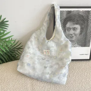Detailed macro view of the ice blue smudge floral pattern on a soft large capacity tote bag