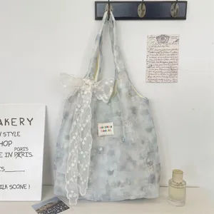 Detailed view of the icy blue marble floral tote bag featuring a white lace bow