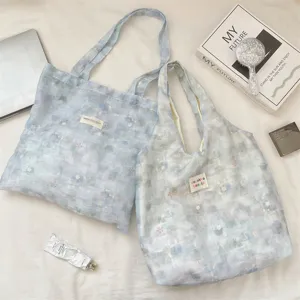 Close-up detail of light blue floral lace tote bags for daily commuting and school use.