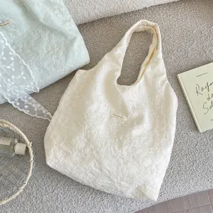 Close-up detail of cream cherry blossom embroidery and gauze texture on large tote bag
