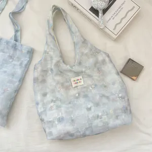 Detailed macro view of the ice blue floral tote bag showing its delicate lace texture.