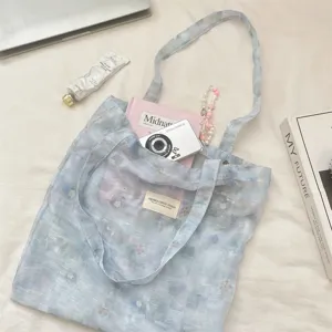 Ice blue floral dyed tote bag showing large capacity with books and camera inside