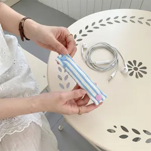 Dettaglio del fermacavo a strisce con bottone a pressione a cuore per auricolari.