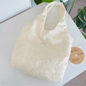 Detailed view of cream-white cherry blossom embroidered tote bag with gauze texture