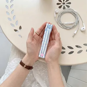 Primo piano di un organizer per cavi a righe blu con bottoni a pressione a cuore.