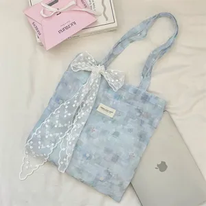 Close-up of ice blue tie-dye floral tote bag with elegant white lace bow decoration