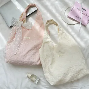 Detail view of cherry blossom embroidered tote bags with delicate lace bow accessory