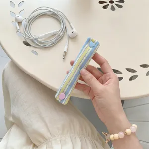 Dettaglio dell'organizzatore per cavi macaron con un bottone a pressione a cuore