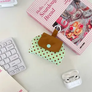 Detailansicht einer grünen gepunkteten Aufbewahrungstasche mit Druckknopf.