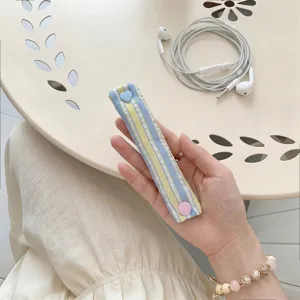Organizzatore per cavi in tessuto a quadretti macaron con bottone a pressione a cuore.