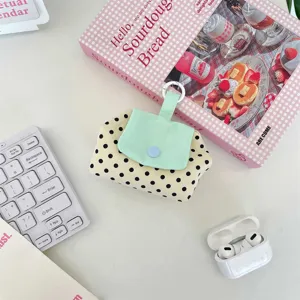 Detailansicht einer kleinen Polka-Dot-Tasche für Kopfhörer und Lippenstift in Minzgrün