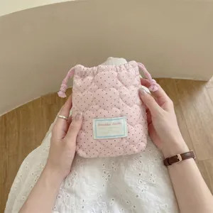 Vista detallada de bolsa con cordón rosa acolchada con corazones y patrón de lunares