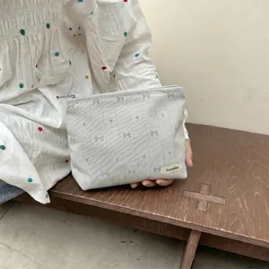 Close-up view of a Japanese style cosmetic bag featuring bow and heart embroidery