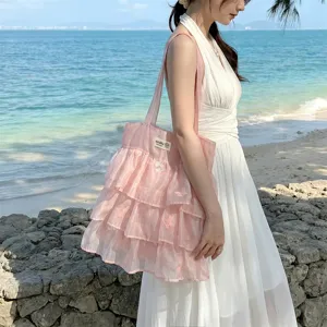 Bolso tote de organza rosa con capas y bordado de mariposas llevado por una modelo