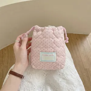 Detalle de una bolsa con cordón acolchada con corazones rosas para maquillaje