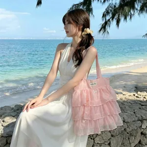 Bolso tote de organza rosa con volantes y bordado de mariposa en playa soleada