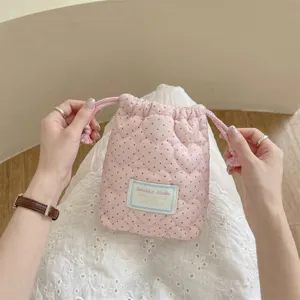 Vista detallada de la bolsa rosa con cordón, acolchado de corazones y lunares negros