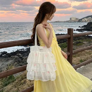 Bolso tote de organza blanco con bordado de mariposas, llevado por una chica al atardecer.