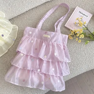 Detalle del bolso tote de organza morado con volantes y bordado floral delicado